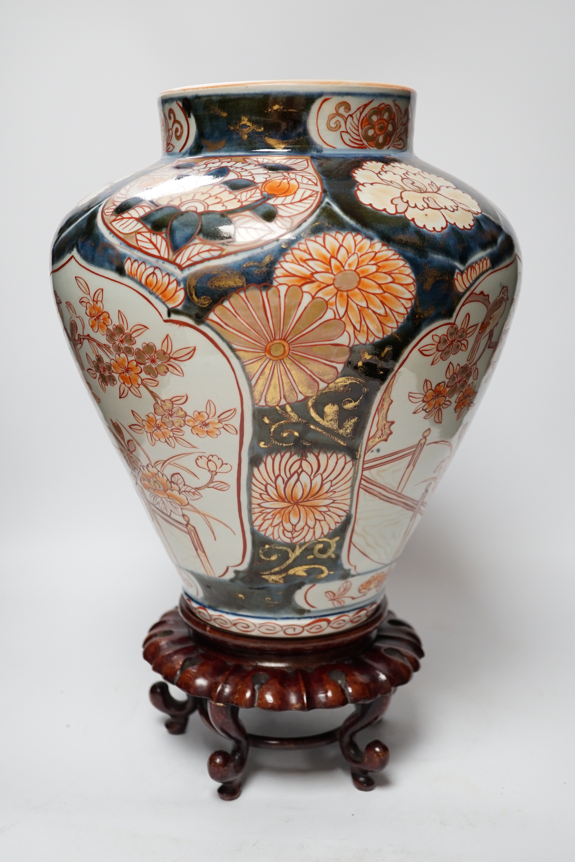 A Japanese Arita Imari pattern vase, c.1690, restored, with an unmatched wooden stand, vase 31cm high